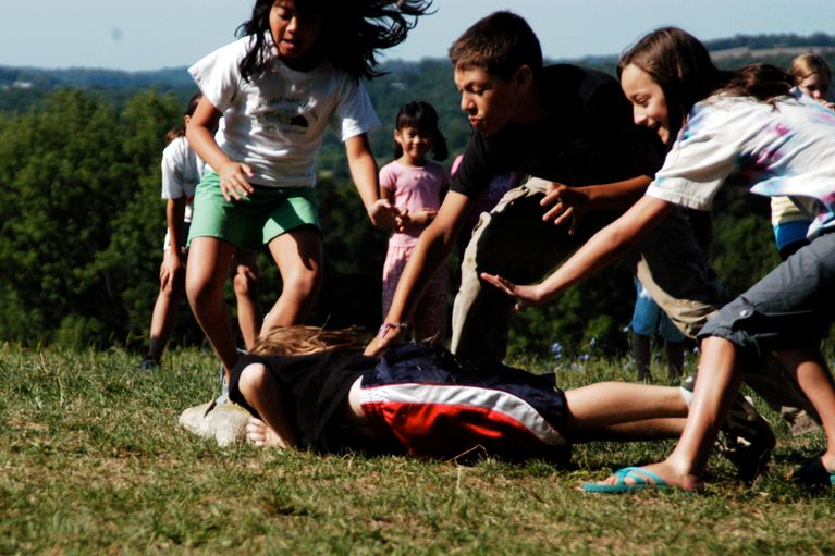 Foto von Kindern, die auf einer großen Wiese Ball spielen. 